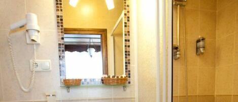 Une salle de bain avec des toilettes, un lavabo et une douche.