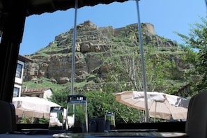 A table with a view of a rocky mountain and a building in the background. - Ugurlu Konaklari (Kastamonu)