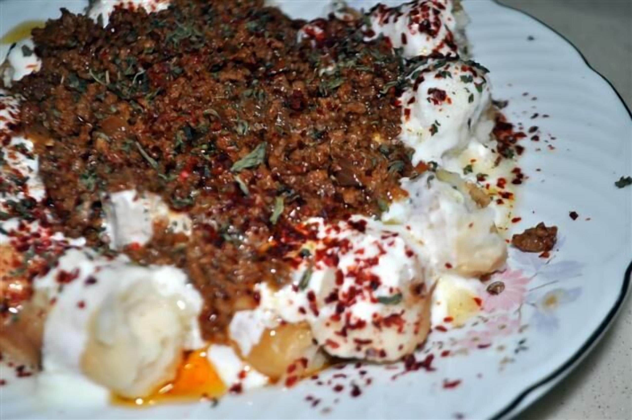 A plate of food with a topping of ground meat, herbs, and spices.