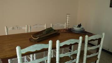 A dining table with a wooden top and white chairs with a distressed finish.