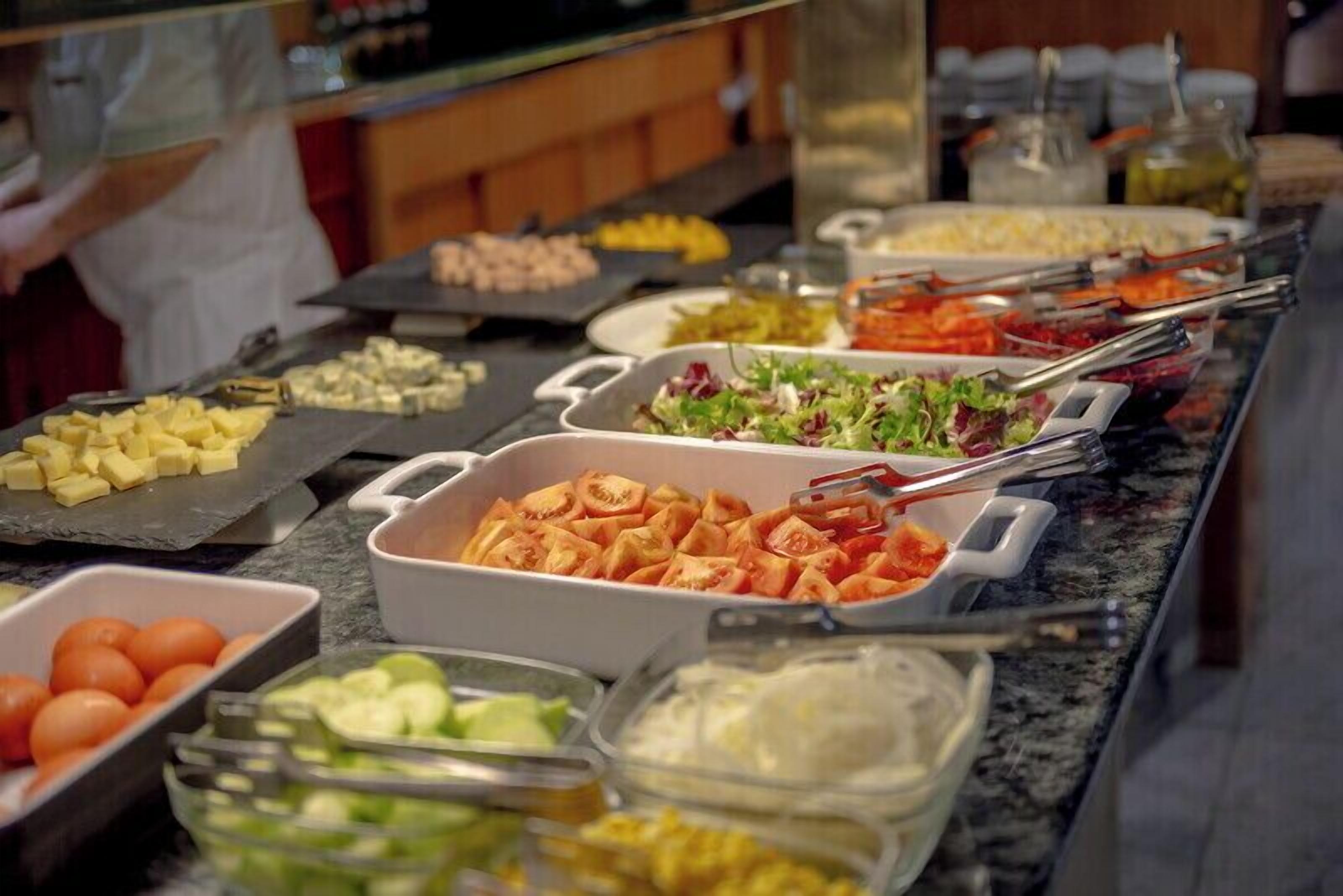 Buffet amb diferents aliments, com fruita, verdura i amanides.