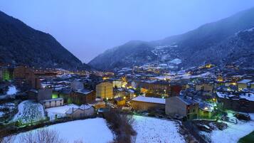 Un pueblo cubierto de nieve con edificios y una montaña al fondo.