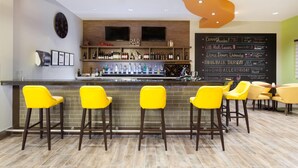 Un espace bar avec un comptoir, des tabourets de bar et un menu écrit à la craie.