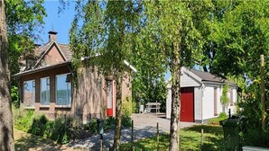 A residential area with houses, a red garage door, and a fenced yard. - Holiday Home Koewacht near Seaside (Koewacht)