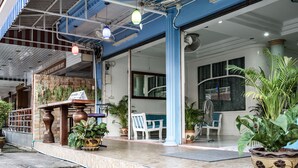 A restaurant with outdoor seating, potted plants, and a sign indicating a room for rent. - Chaam Guesthouse (Cha-am)