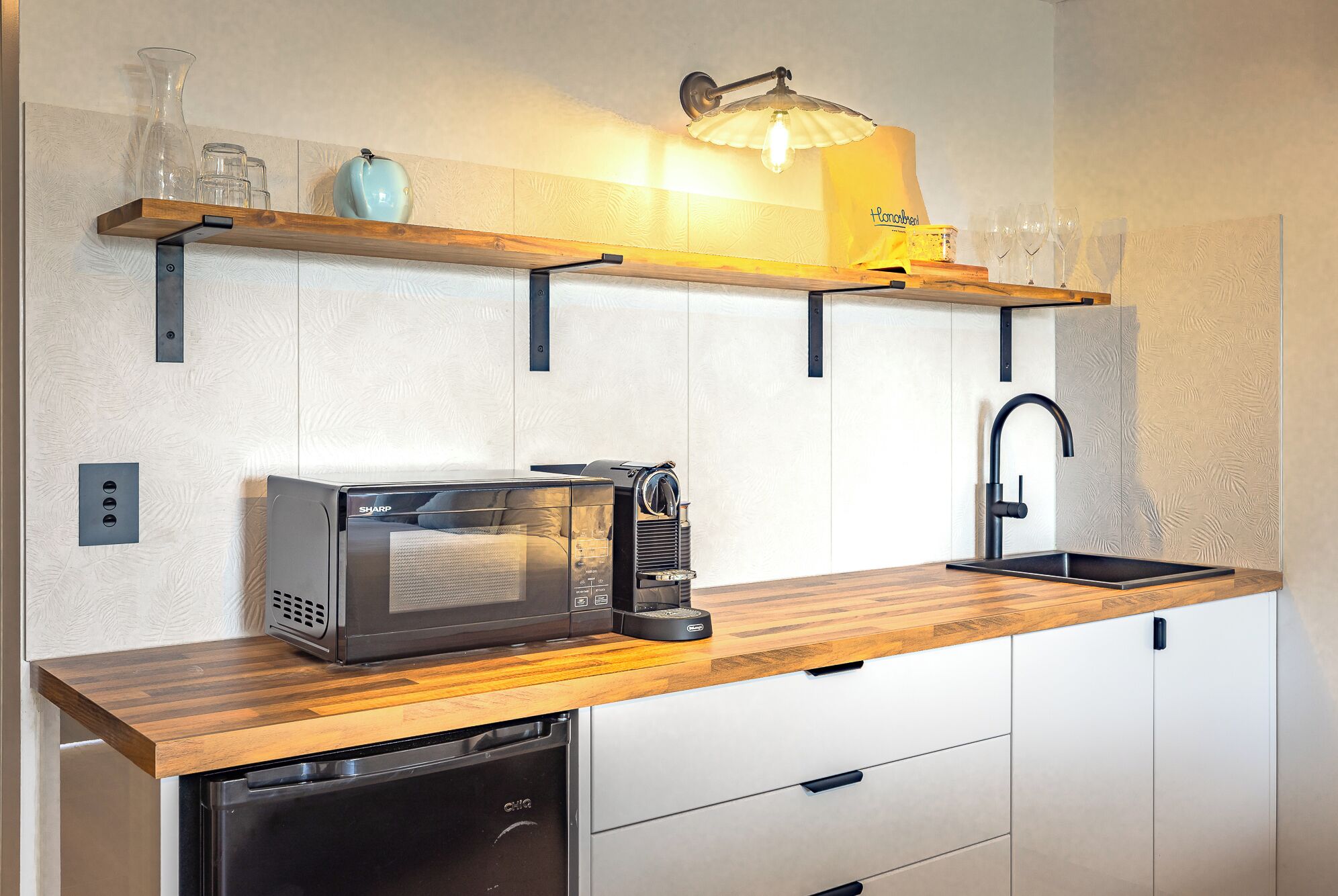 A compact kitchen with a microwave, coffee maker, and dishwasher.