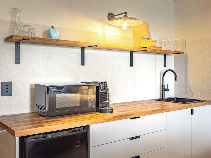 A compact kitchen with a microwave, coffee maker, and dishwasher.