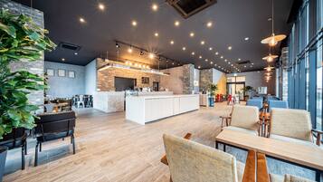 A modern interior with a kitchen area, seating, and large windows.