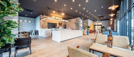 Un interior moderno con zona de cocina, asientos y ventanas amplias.