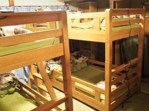 A room with bunk beds, wooden furniture, and a television. - Deer Guesthouse - Hostel (Nara)
