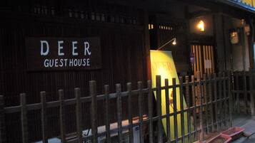 A guesthouse named 'Deer' with a wooden fence and a signboard.