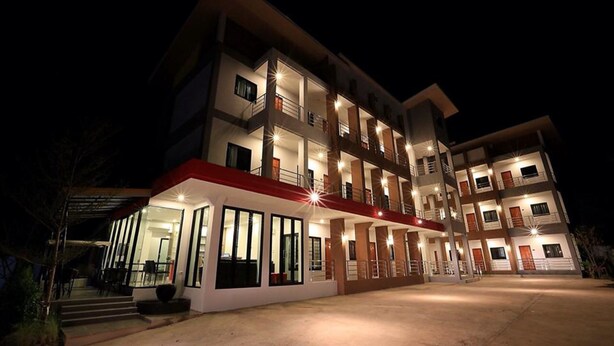A multi-story hotel with a central courtyard, balconies on each floor, and a covered entrance area. - Somsamai Style Apartment (Khon Kaen)