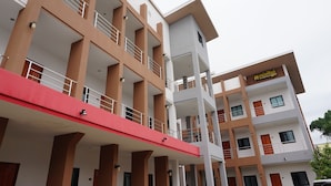 A multi-story hotel with balconies, a red awning, and a sign indicating it is a hotel. - Somsamai Style Apartment (Khon Kaen)