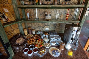 Un bufé con diversos alimentos, como panes, pasteles y salsas.