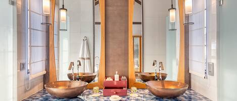 A bathroom with two large copper sinks, a wooden vanity, and a mirror cabinet.