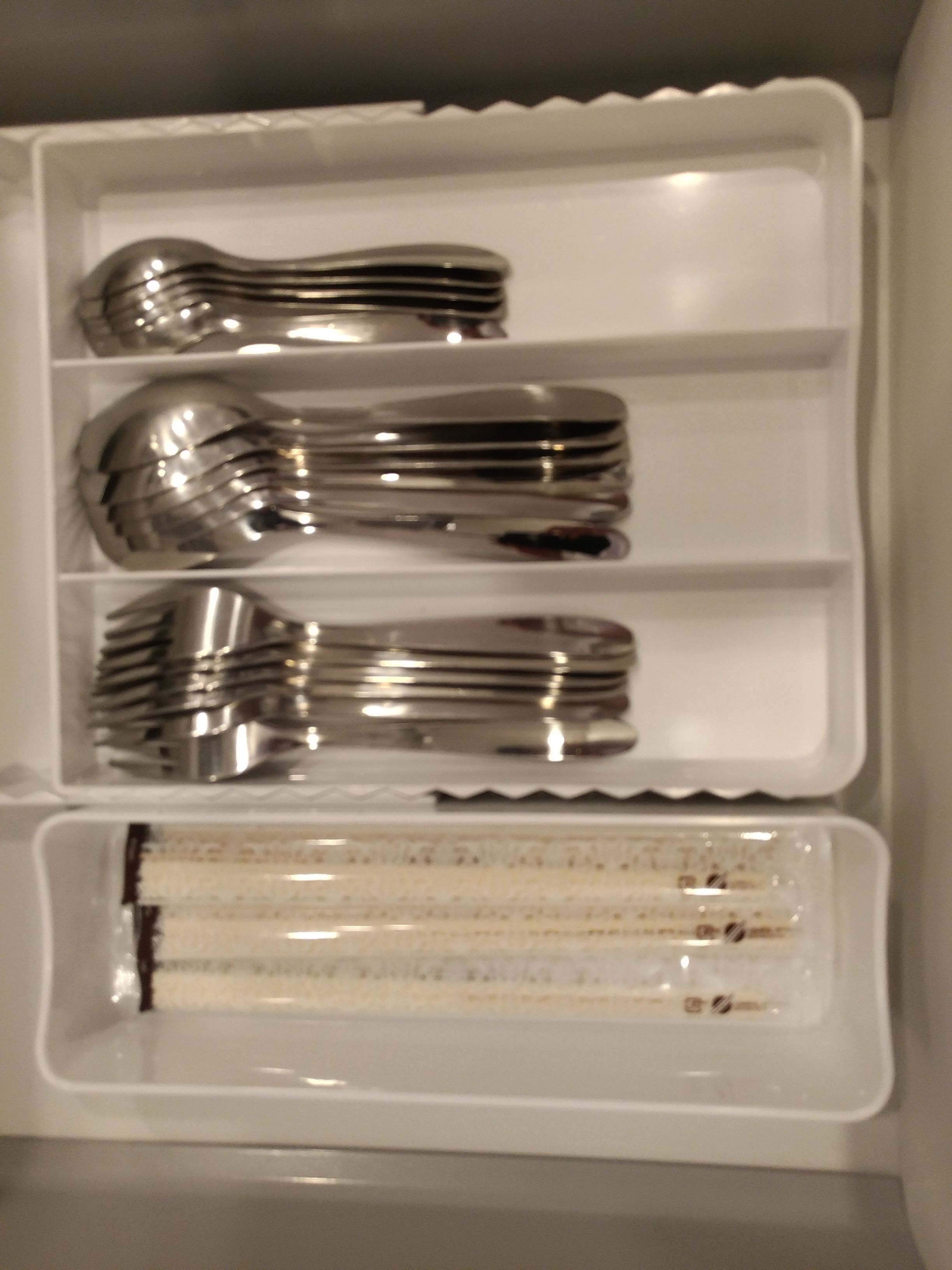 A storage box containing multiple forks and a cake.