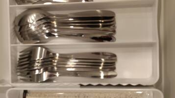 A storage box containing multiple forks and a cake.