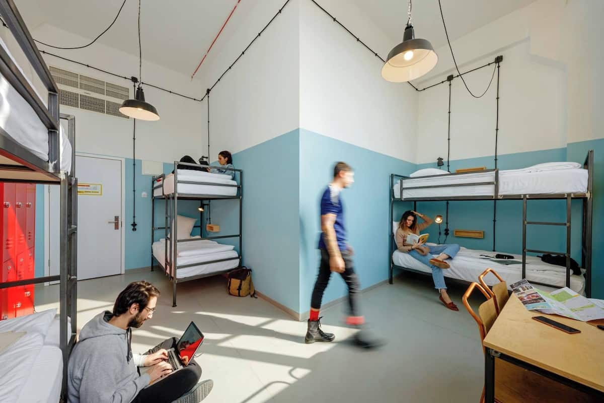 Ein Schlafsaalzimmer mit Etagenbetten, einem Schreibtisch und einem Stuhl.