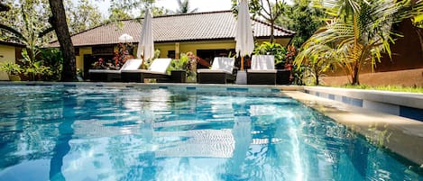 Alberca al aire libre y camastros