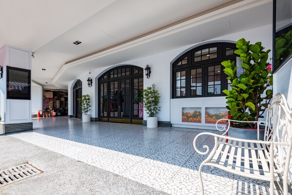A spacious indoor area with tiled flooring, white walls, and black-framed windows. There are potted plants and a white bench. - Norway Forest Travel Hotel 3 Taichung (Taichung)