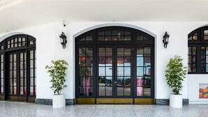 A building facade with arched windows and doors, potted plants, and a tiled floor. - Norway Forest Travel Hotel 3 Taichung (Taichung)