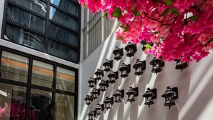 A modern building with large windows, a wall-mounted light fixture, and a potted plant. - Norway Forest Travel Hotel 3 Taichung (Taichung)