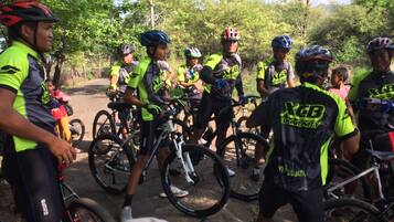 A group of cyclists in a forested area with bicycles and helmets.
