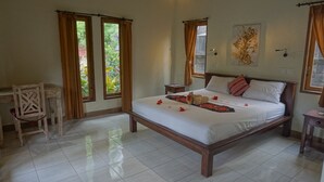 Een slaapkamer met een bed, een stoel, een nachtkastje en een raam met gordijnen.