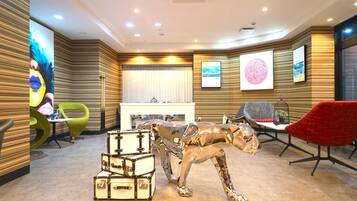 Guests can relax in the stylish lobby, surrounded by a mix of modern and classic seating and artwork.