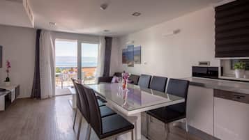 Appartamento Deluxe, 3 camere da letto, balcone, vista mare | Area soggiorno | TV a schermo piatto