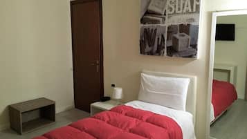 Quarto com cama, mesa de cabeceira, luminária, espelho e porta.