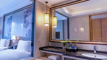 Une salle de bain moderne avec un grand miroir, une baignoire et un meuble-lavabo.