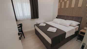 Een moderne hotelkamer met een bed, een bureau en een stoel.