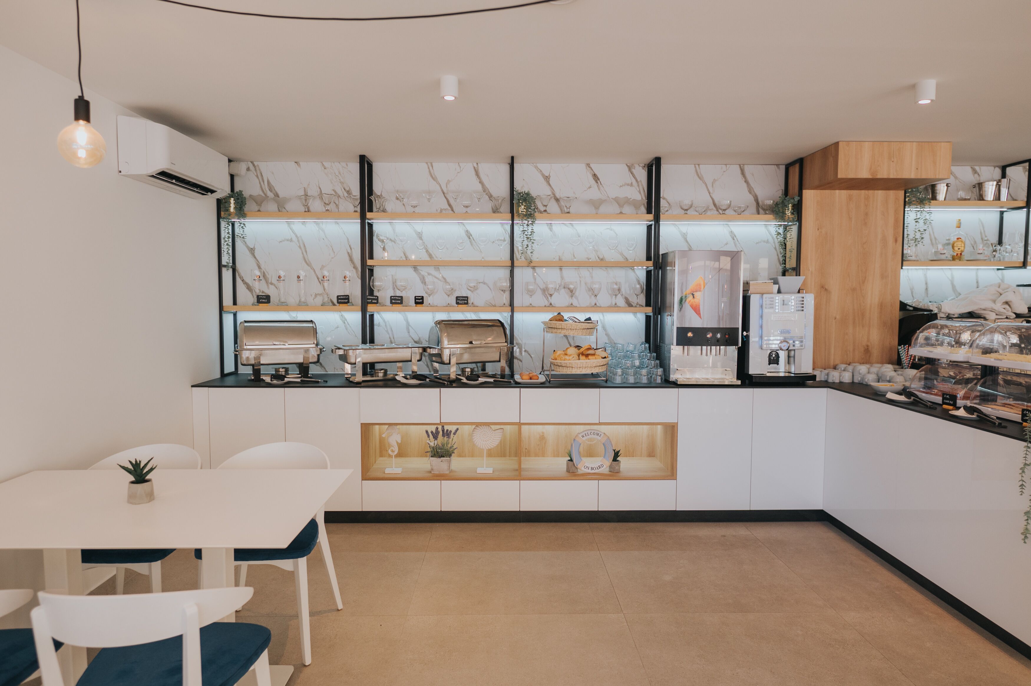 A modern kitchen with marble backsplash, built-in appliances, and a wooden accent wall.