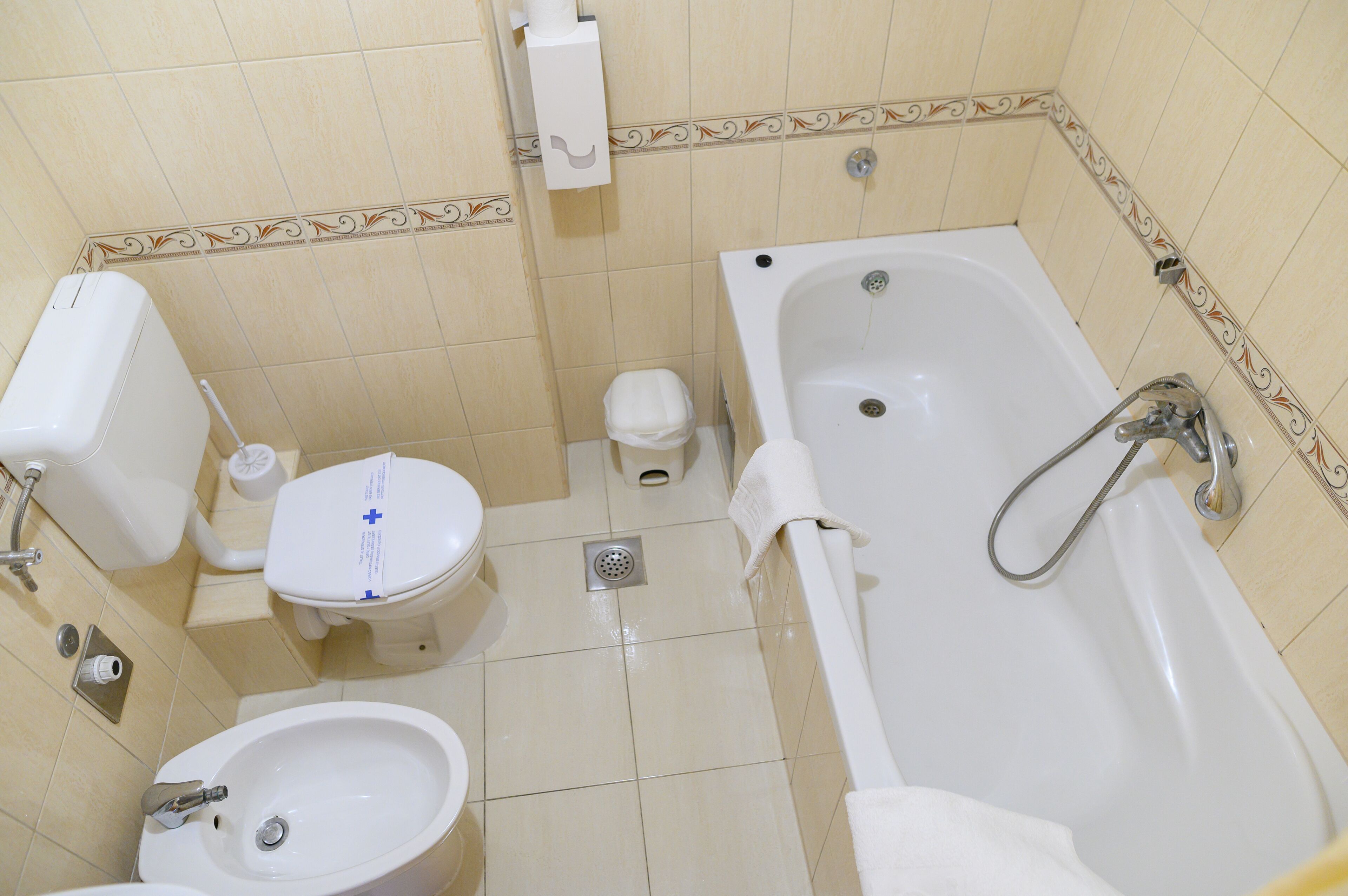 A bathroom with a toilet, bidet, sink, and bathtub.