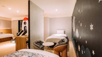 A hotel room with two beds, a desk, a chair, and a wall with a starry design.