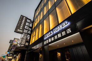 Ein Hotel mit einem gut sichtbaren Schild, auf dem "MEGA HOTEL" steht, sowie weiteren Schildern in einer Fremdsprache.