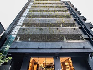 A modern building with a glass facade and a rooftop garden. - CHECK inn SELECT Chiayi RenAi (Chiayi City)
