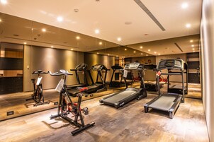 Un gimnasio con cintas de correr, bicicletas estáticas y equipos de ejercicio.