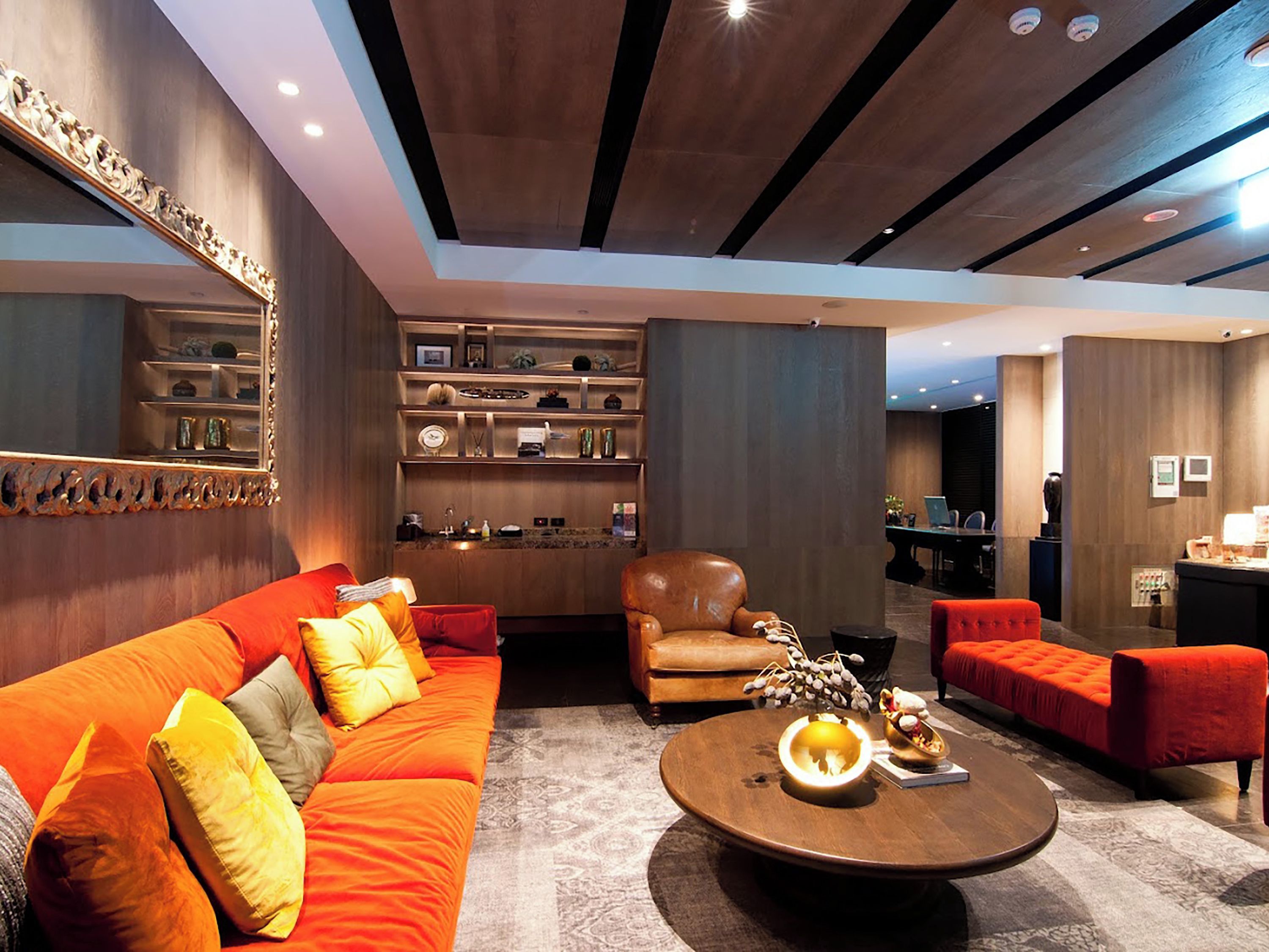 A modern living room with a sofa, armchairs, a coffee table, and a fireplace.