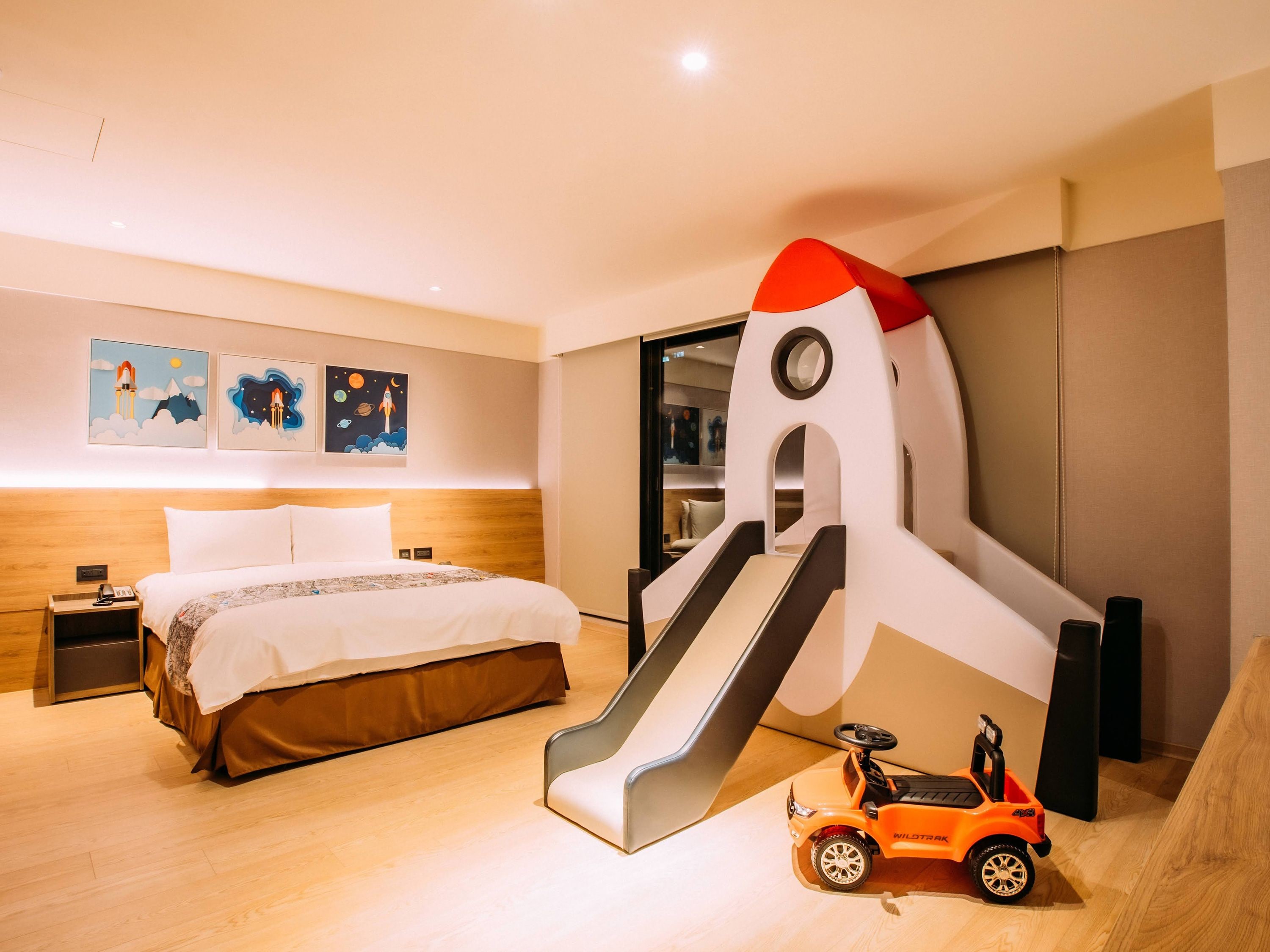 Una habitación de hotel con una cama, una mesita de noche, una obra de arte colgada en la pared y una escultura abstracta de gran tamaño.