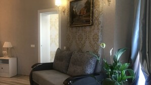 A modern living room with a sofa, a potted plant, and a painting on the wall. - Hotel Bug Brest (Brest)