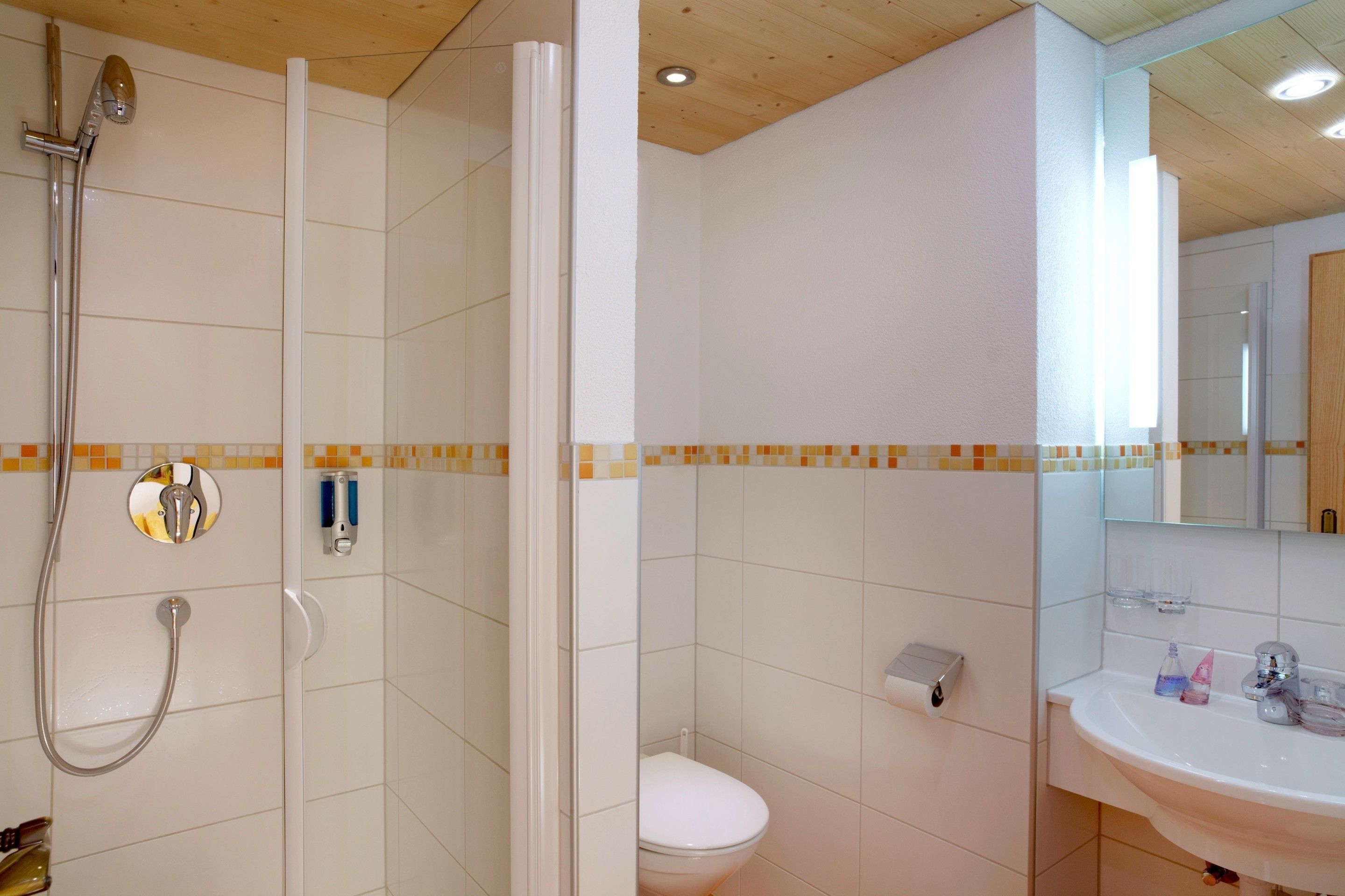 A bathroom with a shower, toilet, and sink.