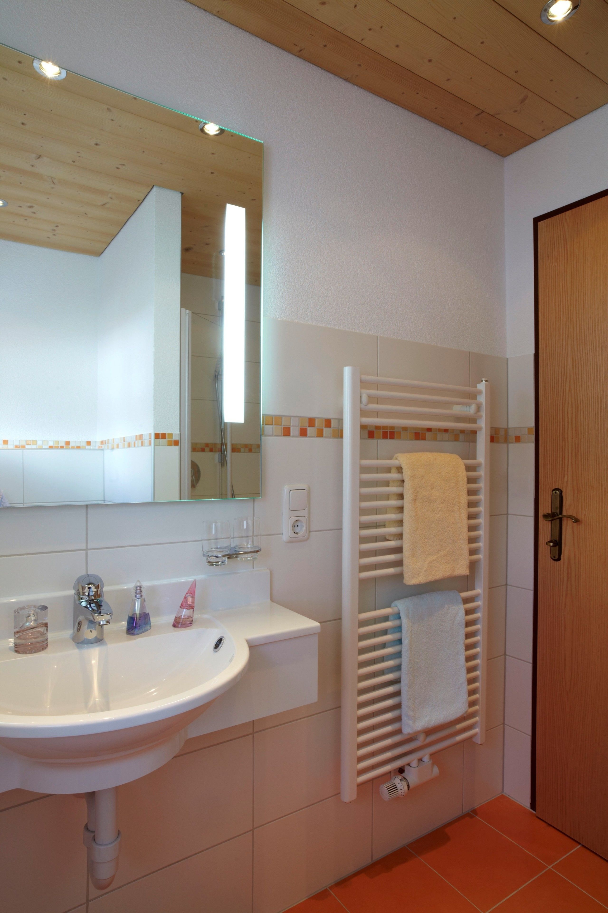 Ein Badezimmer mit Waschbecken, Spiegel und Handtuchhalter.
