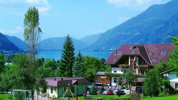 Ein Haus mit rotem Dach, einem Balkon und Blick auf einen See und Berge.