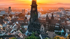 A historic church with a tall spire, surrounded by a dense urban area with various buildings. - Deluxe Studio 9 in der Stadt (Freiburg im Breisgau)