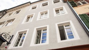 A building facade with multiple windows, some with shutters, and a visible street sign. - Deluxe Studio 9 in der Stadt (Freiburg im Breisgau)