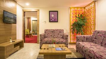 A modern living room with two sofas, a coffee table, and a TV mounted on the wall.