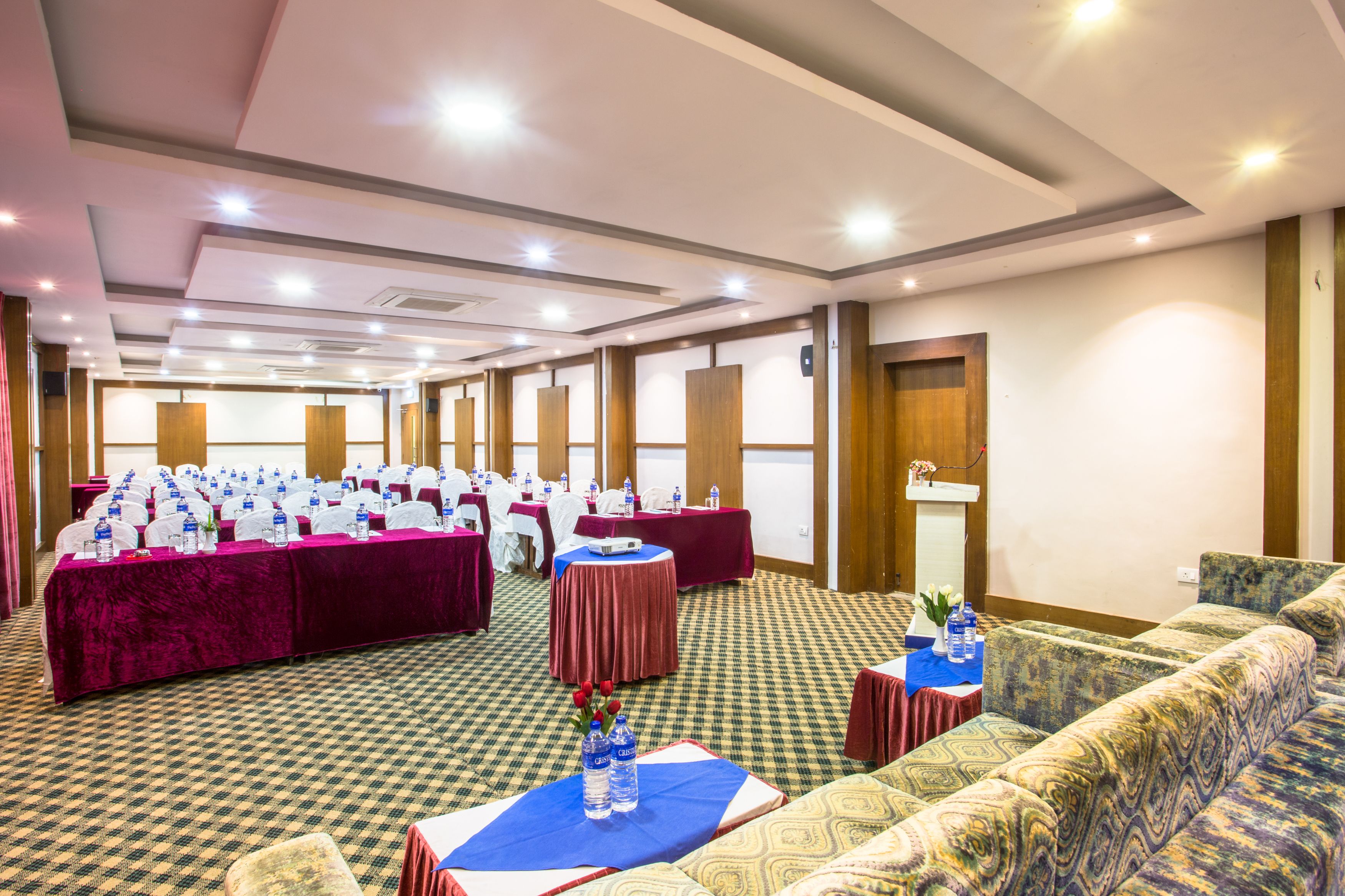 Una sala conferenze con diversi tavoli, sedie e un divano.