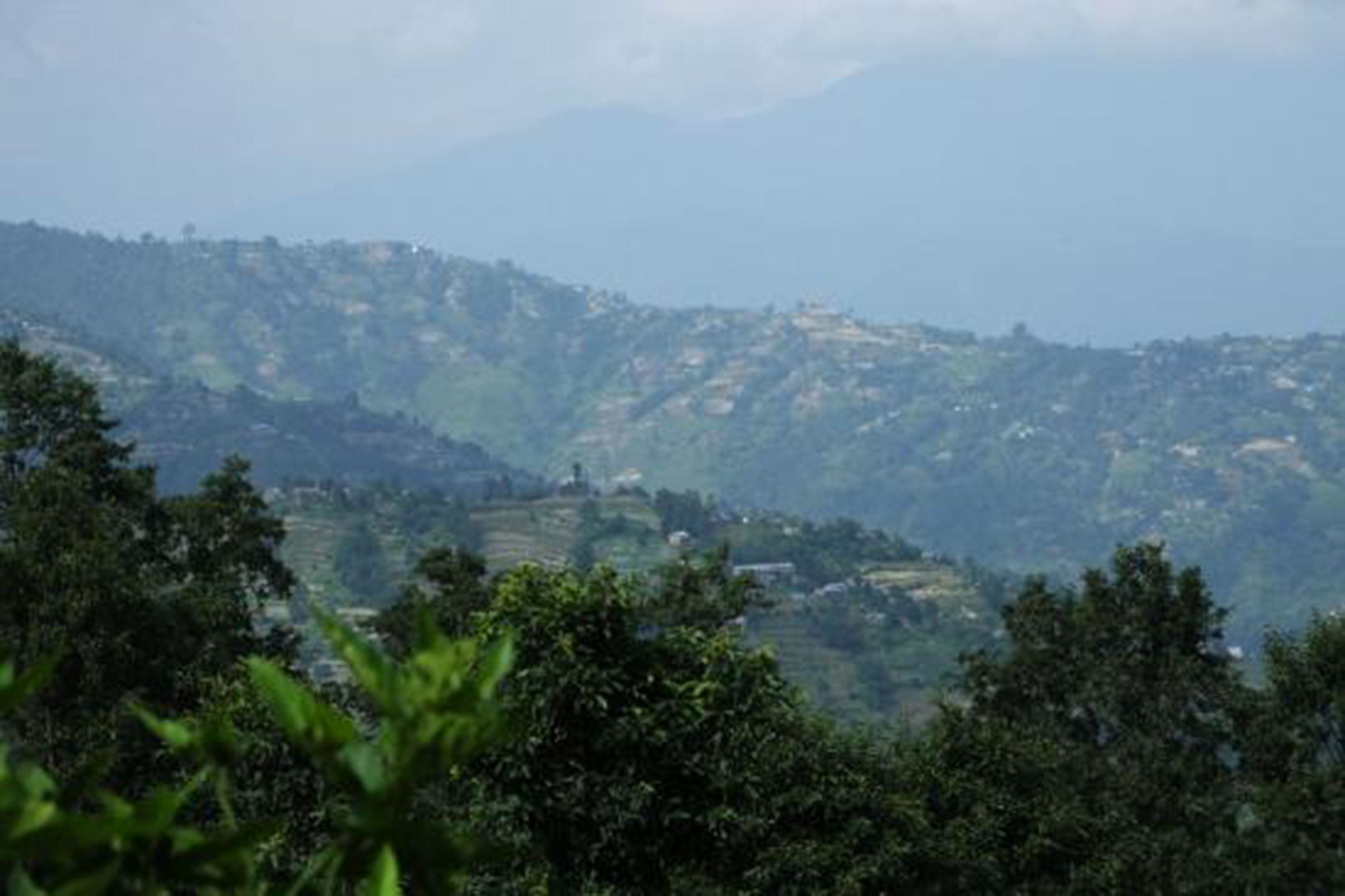 A mountainous landscape with terraced fields and scattered buildings.